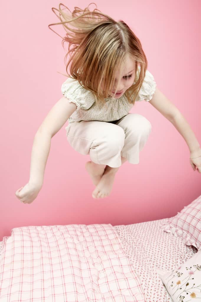 Girl Jumping on Bed --- Image by © Royalty-Free/Corbis